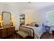 Cozy bedroom featuring hardwood floors, a charming dresser, and a comfortable-looking bed with decorative pillows at 263 Mountainview Cir, Canton, GA 30115