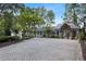 Long brick driveway leading to a white home with a stone entry and well-manicured landscaping at 263 Mountainview Cir, Canton, GA 30115
