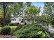 Charming exterior view of a white house featuring mature landscaping and a serene fountain at 263 Mountainview Cir, Canton, GA 30115