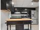 Modern kitchen with black cabinets, a stainless steel refrigerator, and wooden island at 263 Mountainview Cir, Canton, GA 30115