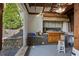 Outdoor kitchen with stone accents, cabinets, and view of backyard at 263 Mountainview Cir, Canton, GA 30115