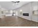 Bright open-concept living space with wood-look floors, a fireplace, and a view of the modern kitchen at 342 Orwell Drive Lot 95, Social Circle, GA 30025