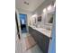 Dual vanity bathroom with gray cabinets, marble countertops, and decorative mirrors at 5085 Johns Creek Ct, Johns Creek, GA 30022