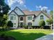 Inviting traditional two-story home featuring a manicured lawn, architectural design, and a charming front entrance at 5085 Johns Creek Ct, Johns Creek, GA 30022