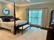 Tranquil bedroom with four-poster bed, neutral tones, and window with natural light at 5085 Johns Creek Ct, Johns Creek, GA 30022