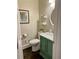 Charming powder room with decorative mirror, green vanity, and nature artwork at 5085 Johns Creek Ct, Johns Creek, GA 30022