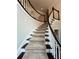 Curved staircase features carpeted steps, a dark wood banister, and white spindles at 5085 Johns Creek Ct, Johns Creek, GA 30022