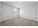 A simple bedroom with neutral carpet, a single window, and an electrical outlet at 358 Orwell Dr, Social Circle, GA 30025