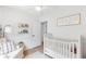Bright Bedroom showcasing a crib, reading nook, and ample space, designed for comfort and functionality at 3794 Brown Owl Ct, Marietta, GA 30062