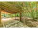 View of large covered patio for outdoor lounging and entertaining nestled in wooded backyard at 800 Greenwood Se Trl, Conyers, GA 30094