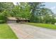 View of the home with a long concrete driveway and attached garage, complemented by a green lawn and mature trees at 800 Greenwood Se Trl, Conyers, GA 30094