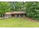 Charming single-story home featuring wood siding, stone accents, and a well-maintained front yard surrounded by mature trees at 800 Greenwood Se Trl, Conyers, GA 30094