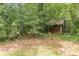 Exterior of an outbuilding nestled amongst mature trees and lush greenery at 800 Greenwood Se Trl, Conyers, GA 30094