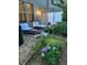 A spacious backyard with patio, outdoor seating, and gravel area featuring lush flower garden and greenery at 2626 Sardis Chase Ct, Buford, GA 30519