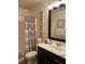 Bathroom featuring a dark vanity, toilet, and decorative shower curtain at 2626 Sardis Chase Ct, Buford, GA 30519