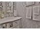 Elegant bathroom vanity with a decorative mirror, stylish wallpaper, and plush towels at 2626 Sardis Chase Ct, Buford, GA 30519