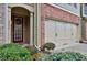Close-up of townhome featuring brick accents, a garage, and a welcoming entrance at 2626 Sardis Chase Ct, Buford, GA 30519