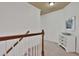 Bright hallway with wooden railing and white drawers topped with a decorative bowl at 2626 Sardis Chase Ct, Buford, GA 30519