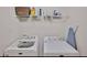 Bright laundry room features a washer, dryer, shelving, and ironing board at 2626 Sardis Chase Ct, Buford, GA 30519