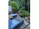 A cozy stone patio featuring patio furniture, lanterns, and garden area with beautiful flower arrangements at 2626 Sardis Chase Ct, Buford, GA 30519