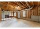 Unfinished basement with exposed beams, concrete flooring and natural light from the windows at 479 Rising Sun Path, Lawrenceville, GA 30043