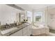 Bright bathroom featuring a dual vanity with granite countertops, a soaking tub, and a glass-enclosed shower at 479 Rising Sun Path, Lawrenceville, GA 30043