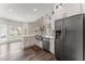 Open kitchen with stainless steel appliances, large farm sink, and view to breakfast nook at 479 Rising Sun Path, Lawrenceville, GA 30043