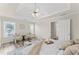 Bright primary bedroom with tray ceiling, sitting area, and serene decor at 479 Rising Sun Path, Lawrenceville, GA 30043