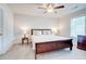 Bedroom features a ceiling fan, carpeted floor, a window, and dark wood furniture at 774 Phil Haven Ln, Kennesaw, GA 30152