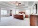 Bedroom featuring a ceiling fan, tray ceiling, sitting area, and dark wood furniture at 774 Phil Haven Ln, Kennesaw, GA 30152