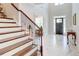 Grand foyer showcasing wood stairs, marble floors, natural light, and view into other rooms at 774 Phil Haven Ln, Kennesaw, GA 30152