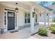 Inviting covered front porch with stone accents, hanging lanterns, and a dark-stained front door at 774 Phil Haven Ln, Kennesaw, GA 30152