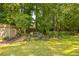 Picturesque backyard featuring a lush lawn, mature trees, and a charming garden with colorful flowers at 840 Milton Oaks Dr, Johns Creek, GA 30022