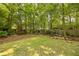 Lush backyard retreat featuring a well-manicured lawn, mature trees, and steps leading to upper area at 840 Milton Oaks Dr, Johns Creek, GA 30022