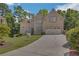 Charming two-story brick home with lush lawn, mature trees, and a wide driveway leading to a two-car garage at 840 Milton Oaks Dr, Johns Creek, GA 30022