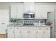Close up on the white kitchen cabinets, granite countertop, modern appliances, and tile backsplash at 840 Milton Oaks Dr, Johns Creek, GA 30022