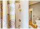Stylish shower with sunflower curtain, tile surround and brass fixtures at 840 Milton Oaks Dr, Johns Creek, GA 30022