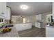 Bright open kitchen with white cabinets, breakfast bar, granite countertops and view to the living area at 2694 Hickory Valley Dr, Snellville, GA 30078