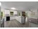 Bright, open kitchen with white cabinetry, stainless steel appliances, and a stone fireplace in the living area at 2694 Hickory Valley Dr, Snellville, GA 30078
