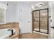 Bright bathroom showcasing a bathtub, a stand up shower with glass door and tile surround at 3055 Dogwood Hollow Ln, Lawrenceville, GA 30043