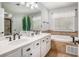 Bathroom featuring dual sinks, white cabinetry, and a separate bathtub with tile surround at 3055 Dogwood Hollow Ln, Lawrenceville, GA 30043