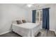 Cozy bedroom with hardwood floors and natural light from the window with blue curtains at 3055 Dogwood Hollow Ln, Lawrenceville, GA 30043