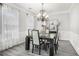 Beautiful dining room featuring an elegant chandelier, wainscoting, neutral decor, and gray wood floors at 3055 Dogwood Hollow Ln, Lawrenceville, GA 30043