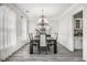 Formal dining room with elegant lighting, wainscoting detail, gray floors, and space for entertaining at 3055 Dogwood Hollow Ln, Lawrenceville, GA 30043