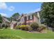 Stunning view of a brick home with lush greenery, a well-kept lawn, and architectural appeal at 3055 Dogwood Hollow Ln, Lawrenceville, GA 30043