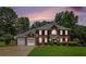 Charming two-story brick home with a well-manicured lawn, lush landscaping, and a two-car garage at 3055 Dogwood Hollow Ln, Lawrenceville, GA 30043