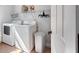 Functional laundry room features a washer, dryer, shelving and white walls at 3055 Dogwood Hollow Ln, Lawrenceville, GA 30043