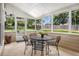 Inviting sunroom with multiple windows and table and chairs overlooking the backyard at 3055 Dogwood Hollow Ln, Lawrenceville, GA 30043