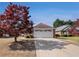 Charming brick home featuring a spacious driveway and a well-maintained front yard, accented by a beautiful red tree at 3264 Salem Cove Se Trl, Conyers, GA 30013
