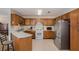 Functional kitchen with tile floors, stainless steel appliances, and wooden cabinets, offering a practical cooking space at 3264 Salem Cove Se Trl, Conyers, GA 30013